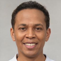 Joyful latino young-adult male with short  brown hair and brown eyes