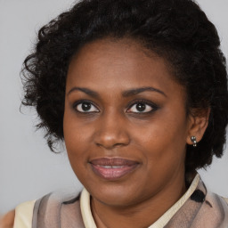 Joyful black young-adult female with long  brown hair and brown eyes