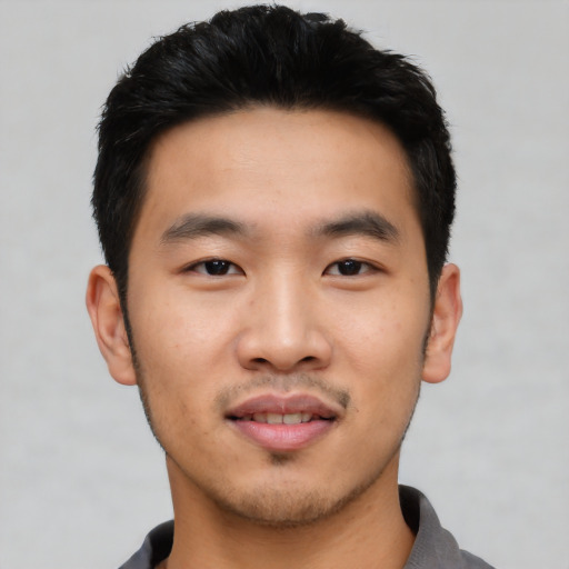 Joyful asian young-adult male with short  black hair and brown eyes