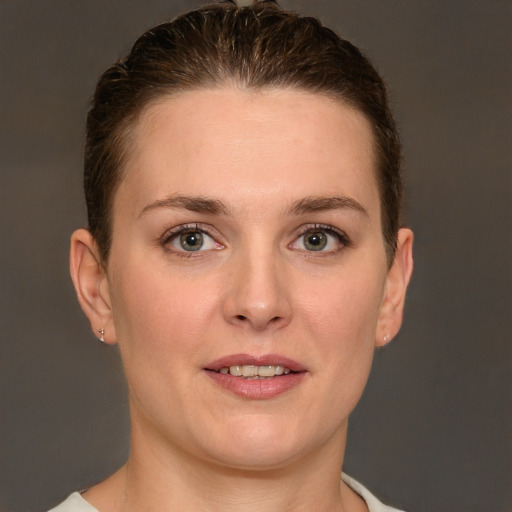 Joyful white young-adult female with short  brown hair and grey eyes