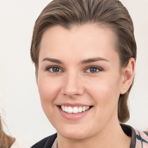 Joyful white young-adult female with medium  brown hair and grey eyes