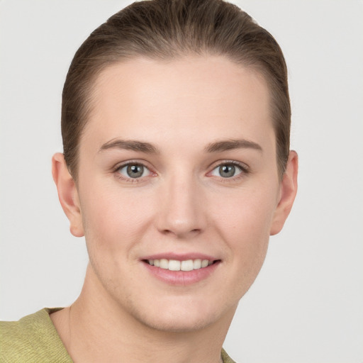 Joyful white young-adult female with short  brown hair and grey eyes