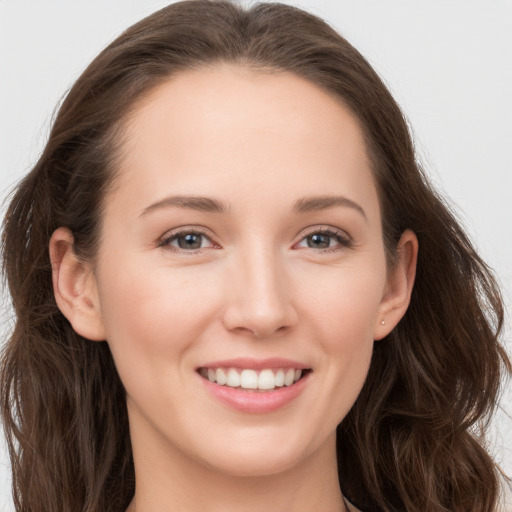 Joyful white young-adult female with long  brown hair and grey eyes