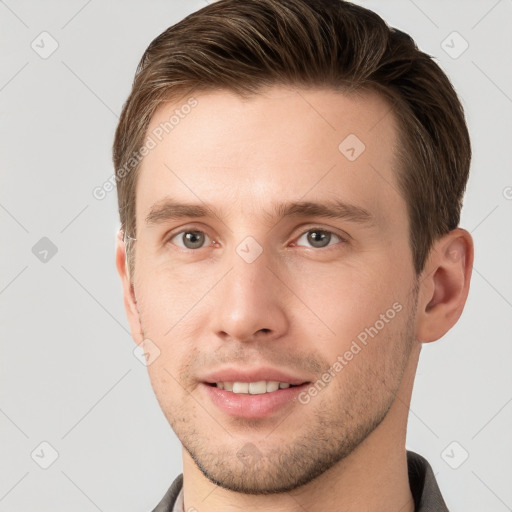 Joyful white young-adult male with short  brown hair and grey eyes