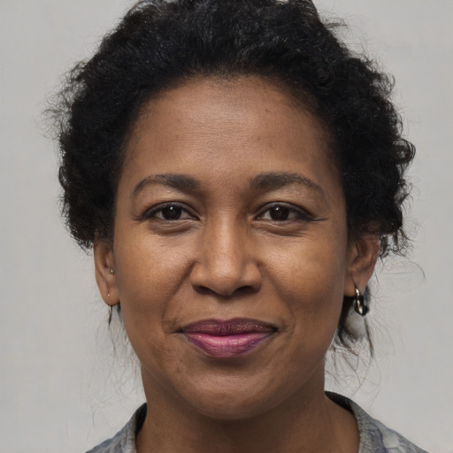 Joyful black adult female with short  brown hair and brown eyes