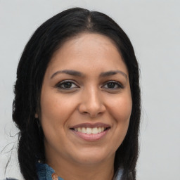 Joyful latino young-adult female with long  brown hair and brown eyes