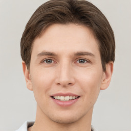 Joyful white young-adult male with short  brown hair and grey eyes