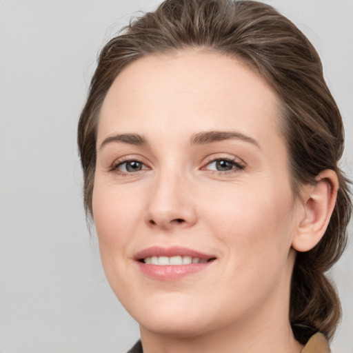 Joyful white young-adult female with medium  brown hair and grey eyes