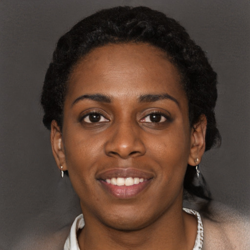 Joyful black young-adult female with short  black hair and brown eyes