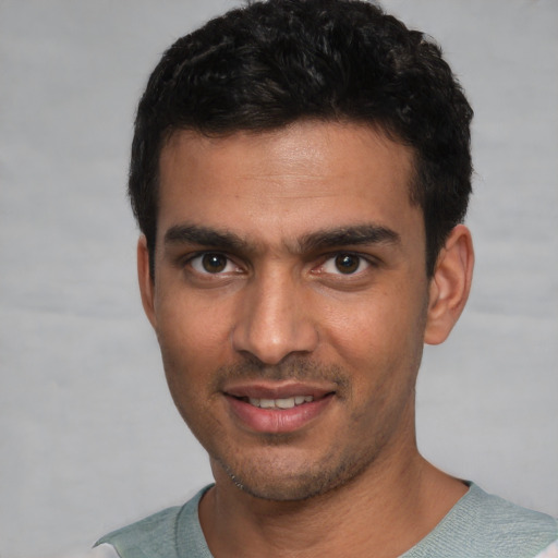 Joyful white young-adult male with short  black hair and brown eyes