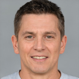 Joyful white adult male with short  brown hair and brown eyes