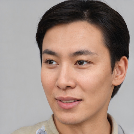 Joyful asian young-adult male with short  brown hair and brown eyes
