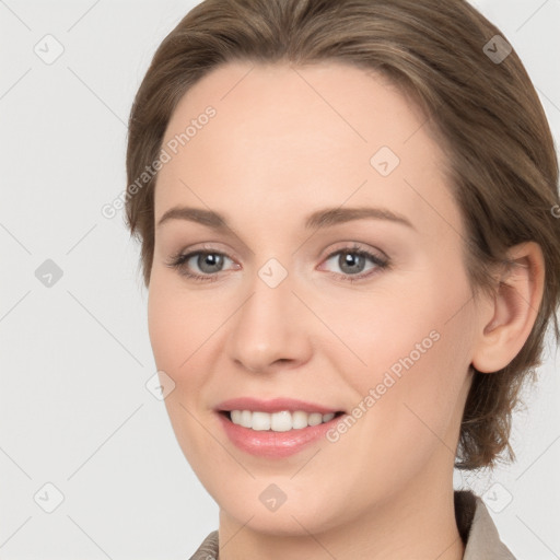 Joyful white young-adult female with medium  brown hair and grey eyes