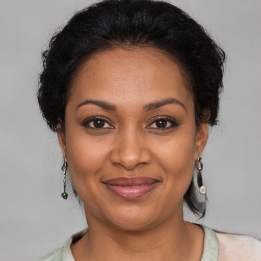 Joyful black adult female with short  brown hair and brown eyes