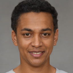 Joyful black adult male with short  black hair and brown eyes