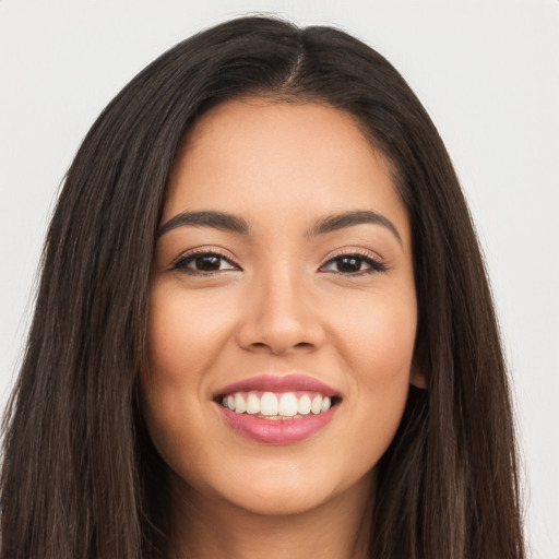 Joyful latino young-adult female with long  brown hair and brown eyes