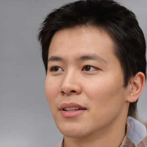 Joyful asian young-adult male with short  brown hair and brown eyes