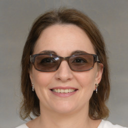 Joyful white young-adult female with medium  brown hair and blue eyes