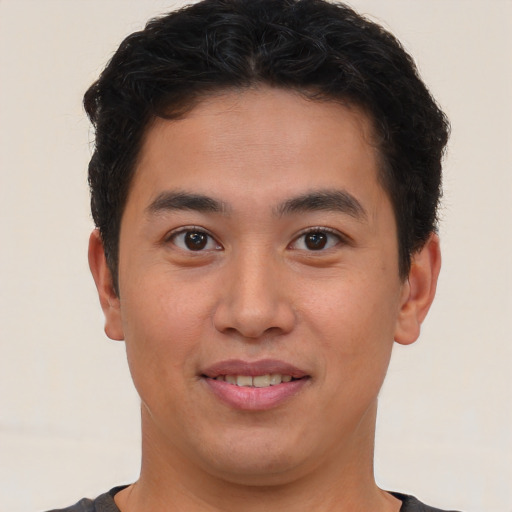 Joyful latino young-adult male with short  brown hair and brown eyes