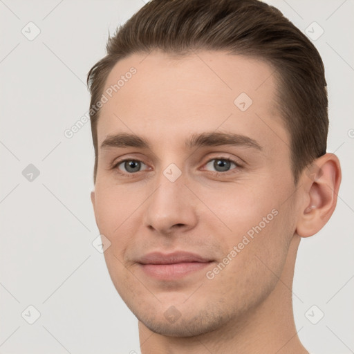 Joyful white young-adult male with short  brown hair and grey eyes