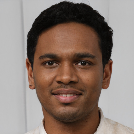 Joyful black young-adult male with short  black hair and brown eyes