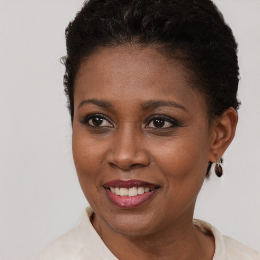 Joyful black young-adult female with short  brown hair and brown eyes