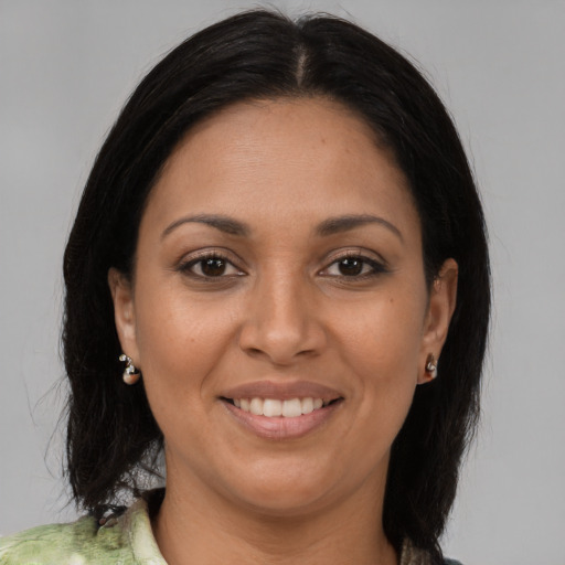 Joyful latino adult female with long  brown hair and brown eyes