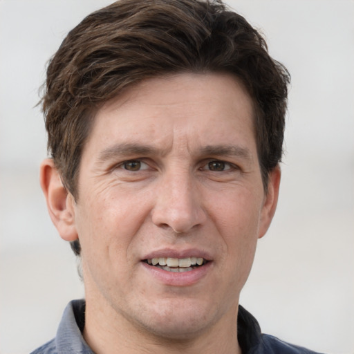 Joyful white adult male with short  brown hair and grey eyes