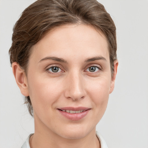 Joyful white young-adult female with short  brown hair and grey eyes