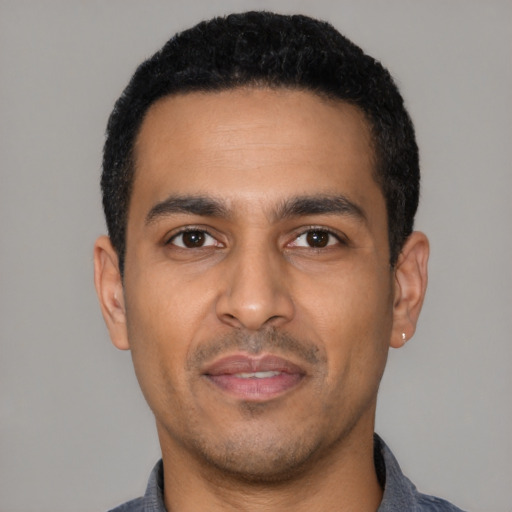 Joyful latino young-adult male with short  black hair and brown eyes