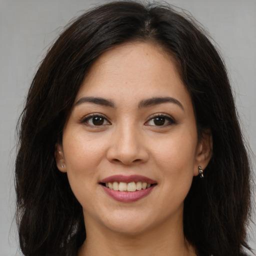 Joyful latino young-adult female with long  brown hair and brown eyes