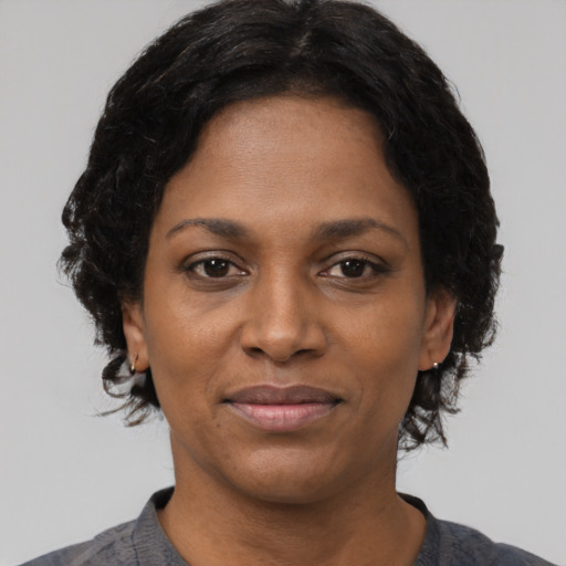 Joyful black young-adult female with short  black hair and brown eyes