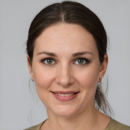 Joyful white young-adult female with medium  brown hair and grey eyes