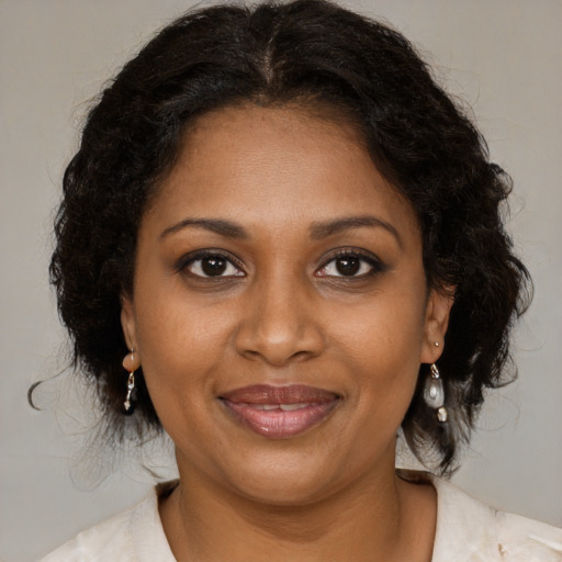 Joyful black adult female with medium  brown hair and brown eyes