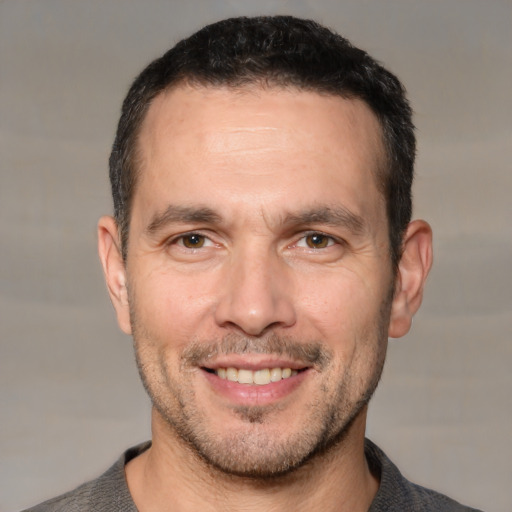 Joyful white adult male with short  brown hair and brown eyes