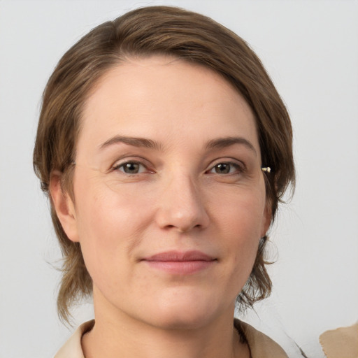 Joyful white young-adult female with medium  brown hair and grey eyes