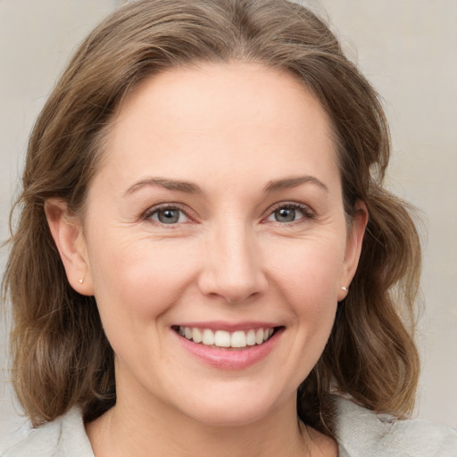 Joyful white young-adult female with medium  brown hair and grey eyes