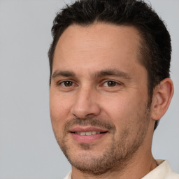 Joyful white adult male with short  brown hair and brown eyes