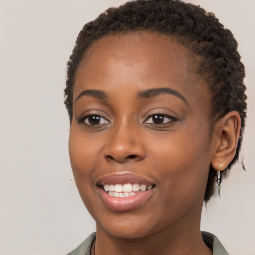 Joyful black young-adult female with short  brown hair and brown eyes