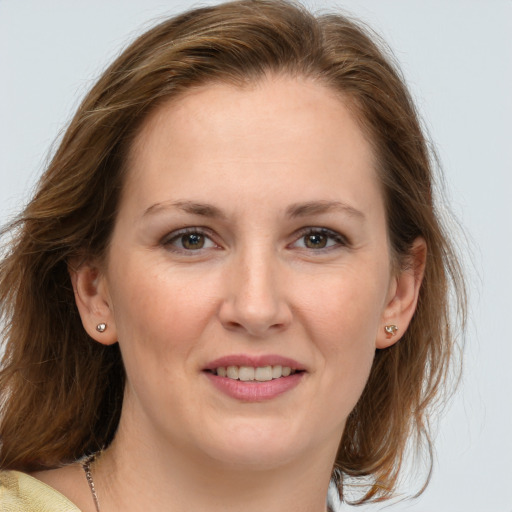 Joyful white young-adult female with medium  brown hair and blue eyes