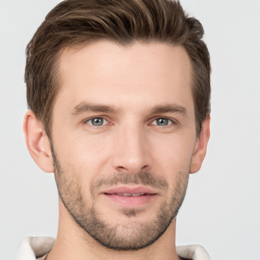 Joyful white young-adult male with short  brown hair and grey eyes