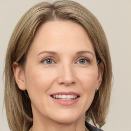 Joyful white adult female with medium  brown hair and grey eyes