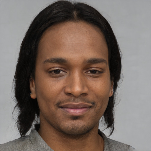 Joyful black young-adult male with medium  black hair and brown eyes
