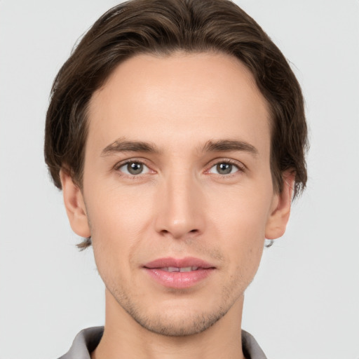 Joyful white young-adult male with short  brown hair and grey eyes