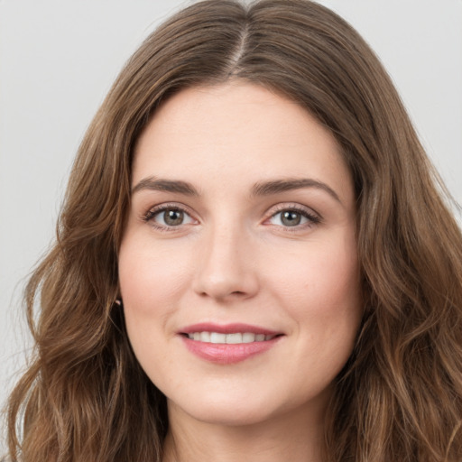 Joyful white young-adult female with long  brown hair and green eyes