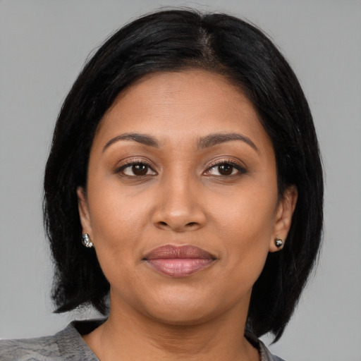 Joyful latino adult female with medium  brown hair and brown eyes