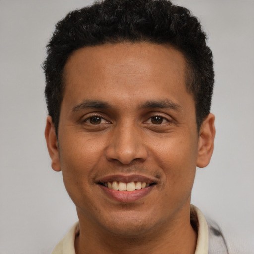 Joyful latino young-adult male with short  black hair and brown eyes