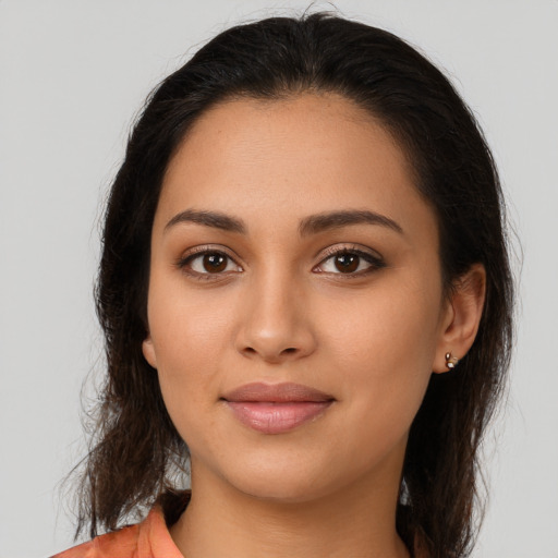 Joyful latino young-adult female with long  brown hair and brown eyes