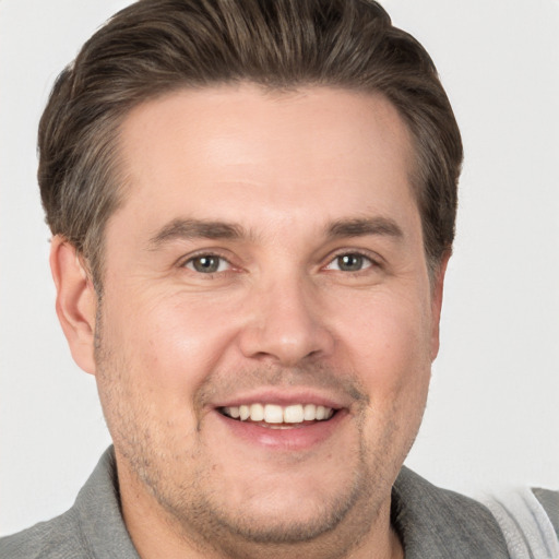 Joyful white adult male with short  brown hair and grey eyes