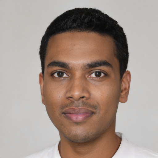 Joyful black young-adult male with short  black hair and brown eyes